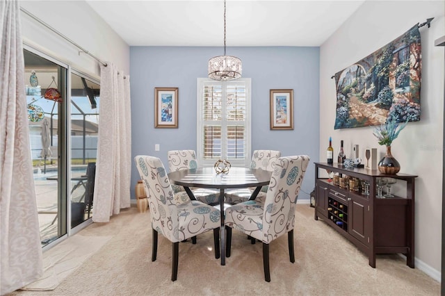 dining space with an inviting chandelier and light colored carpet