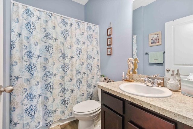 bathroom featuring vanity, toilet, and walk in shower