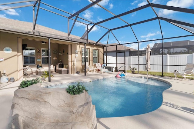 view of swimming pool featuring ceiling fan, a lanai, and a patio area