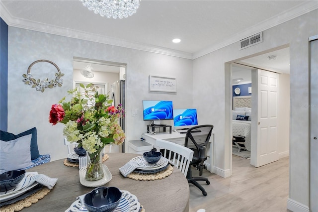 office area featuring an inviting chandelier, crown molding, and light wood-type flooring