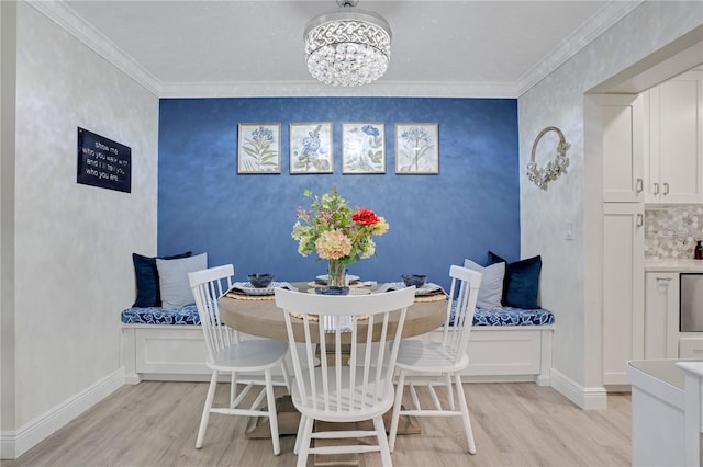 dining room with crown molding, light hardwood / wood-style flooring, and a chandelier