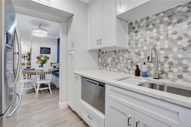 kitchen with white cabinetry, stainless steel fridge with ice dispenser, decorative backsplash, and sink