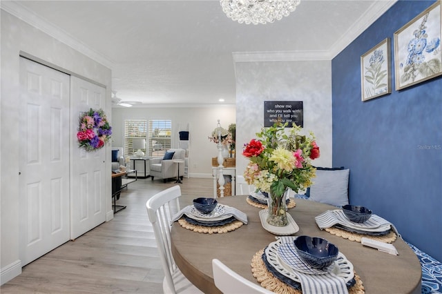 dining area featuring ornamental molding, ceiling fan with notable chandelier, and light hardwood / wood-style flooring