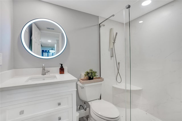 bathroom featuring vanity, a shower with shower door, and toilet