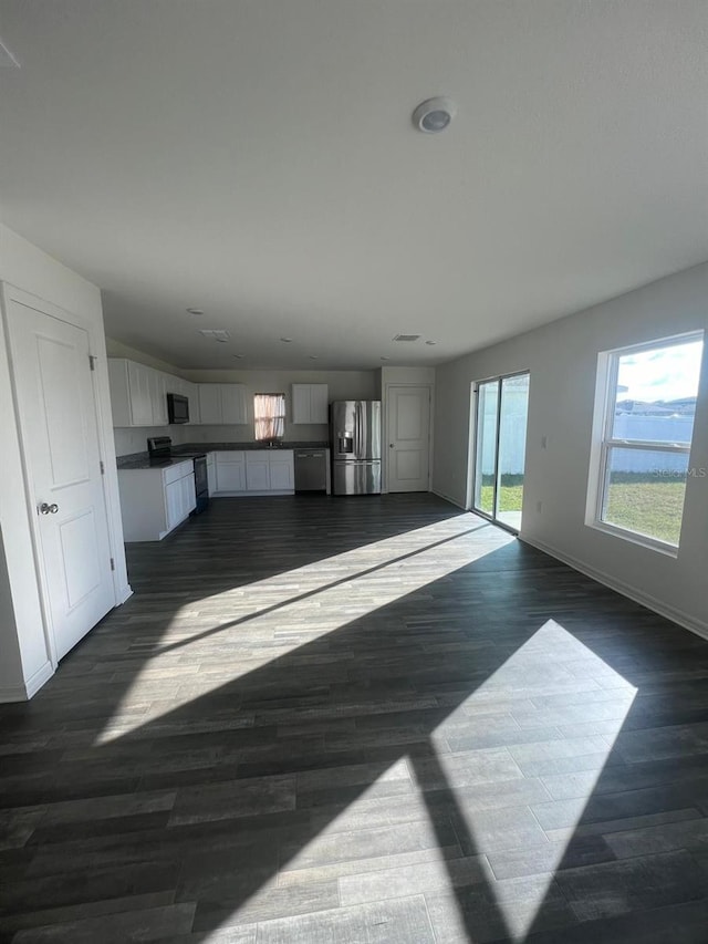 unfurnished living room with dark hardwood / wood-style flooring