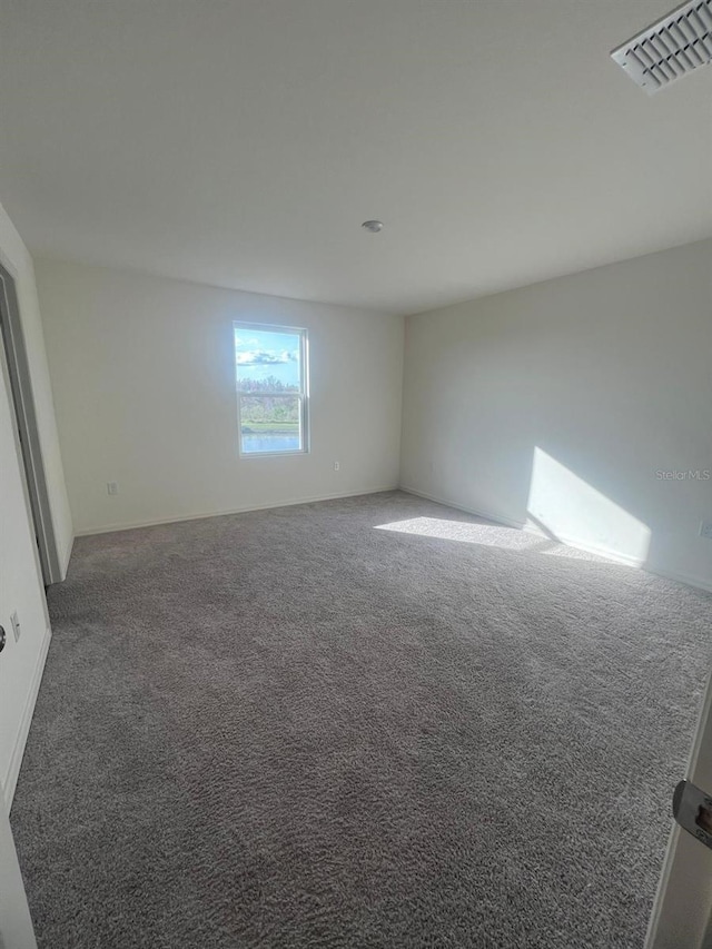 spare room with dark carpet