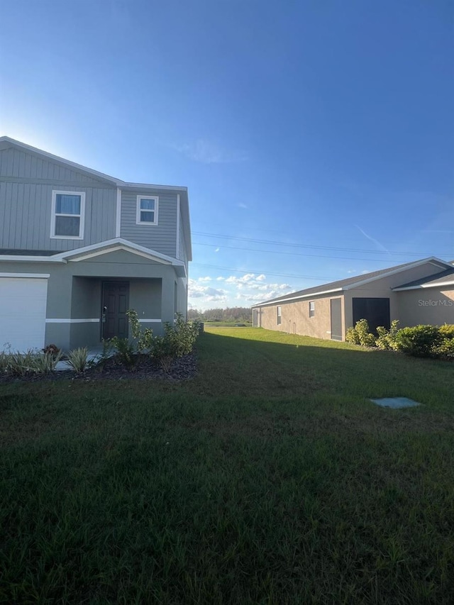 view of property exterior featuring a garage and a lawn