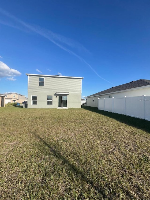 rear view of property featuring a lawn