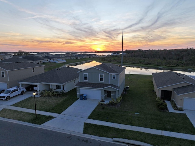 aerial view at dusk featuring a water view