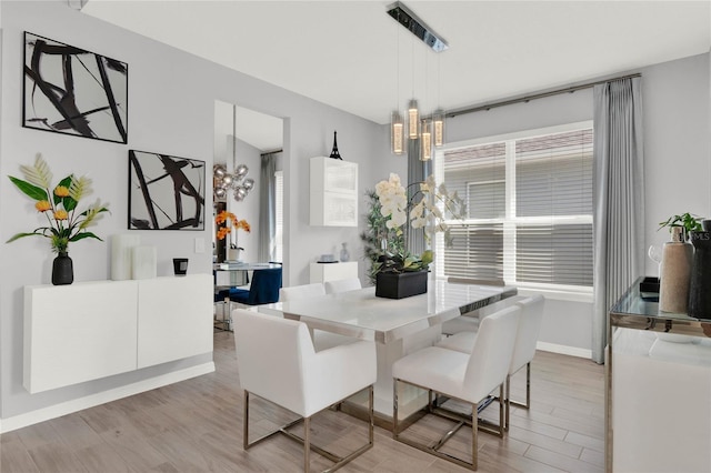 dining area featuring an inviting chandelier and light hardwood / wood-style flooring