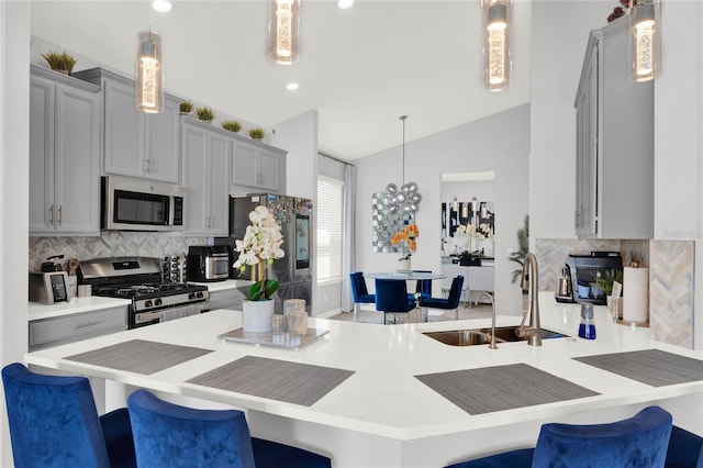 kitchen featuring stainless steel appliances, hanging light fixtures, and a breakfast bar