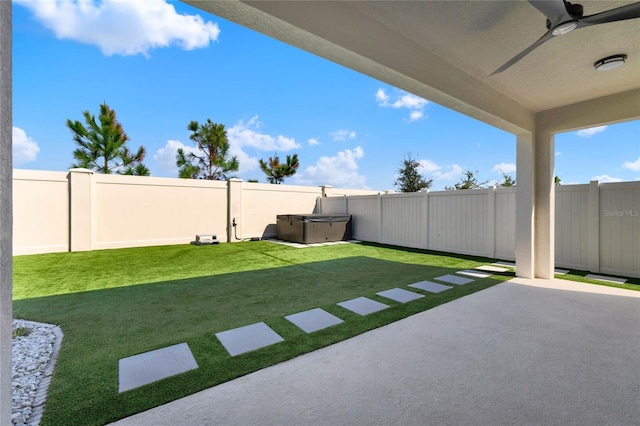 view of yard featuring a patio area, a hot tub, and ceiling fan