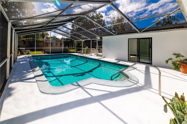 view of swimming pool with a storage shed, a lanai, and a patio