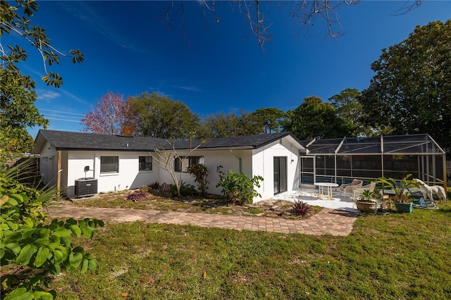 back of property with cooling unit, a yard, a lanai, and a patio