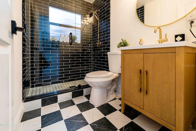 bathroom featuring vanity, a tile shower, and toilet