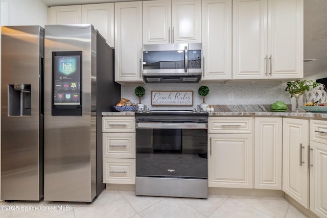 kitchen with stainless steel appliances, light tile patterned flooring, backsplash, and light stone counters