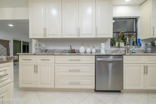 kitchen featuring light tile patterned floors, sink, dark stone countertops, decorative backsplash, and stainless steel dishwasher