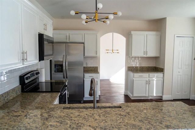 kitchen with decorative light fixtures, stainless steel appliances, and white cabinets