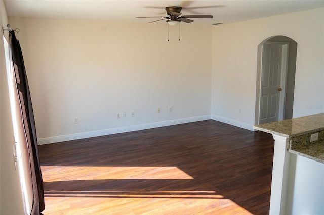 spare room featuring dark hardwood / wood-style flooring and ceiling fan