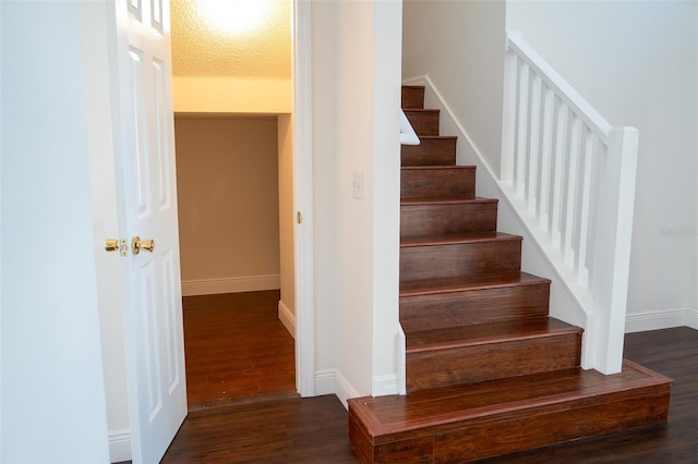 stairs featuring hardwood / wood-style floors and a textured ceiling