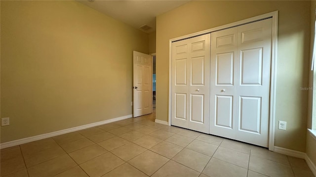 unfurnished bedroom featuring light tile patterned floors and a closet