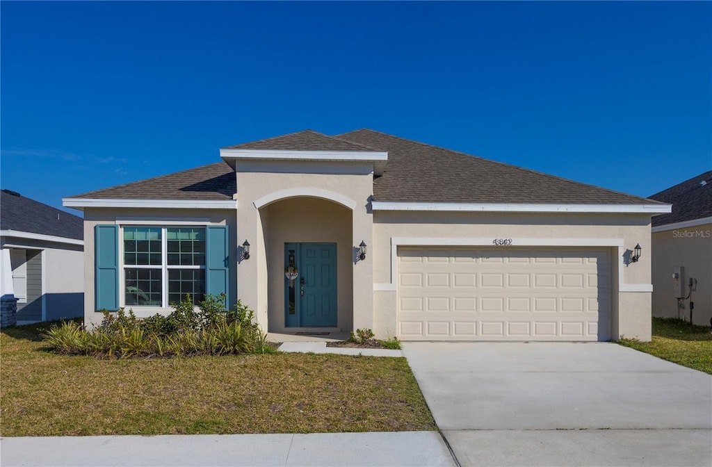 view of front facade with a garage and a front lawn