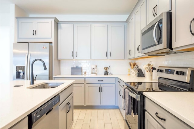 kitchen with appliances with stainless steel finishes, sink, and decorative backsplash