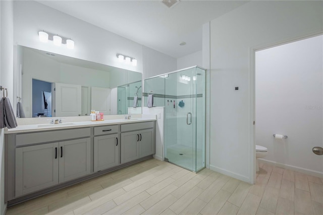 bathroom featuring vanity, an enclosed shower, hardwood / wood-style floors, and toilet