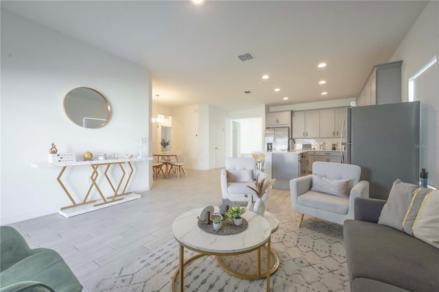 living room featuring sink and light hardwood / wood-style floors