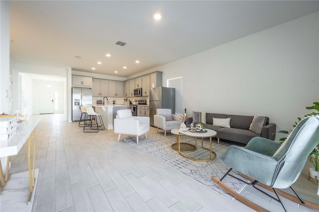 living room with sink and light hardwood / wood-style flooring