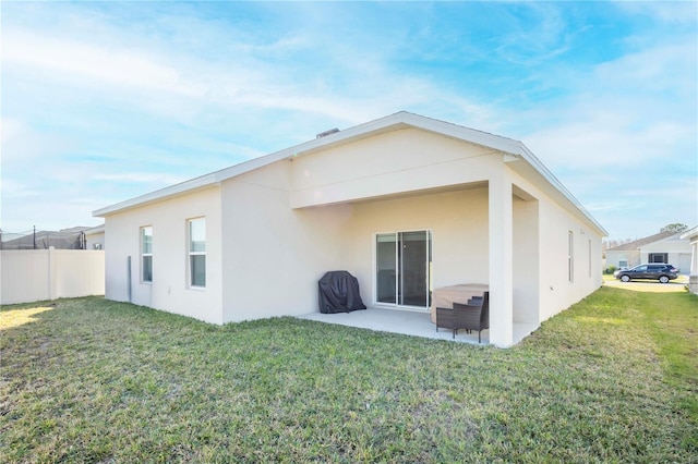 rear view of property with a yard and a patio area