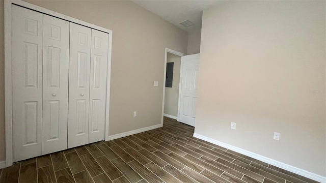 unfurnished bedroom with electric panel and a closet