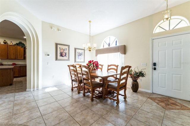 tiled dining room featuring a chandelier