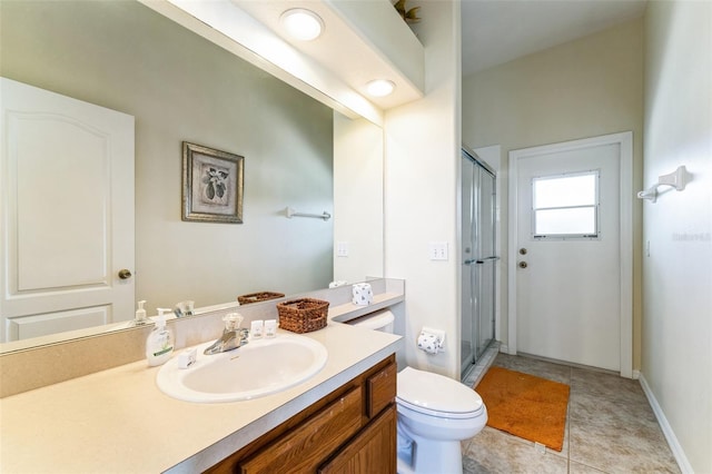 bathroom featuring a shower with door, vanity, tile patterned floors, and toilet