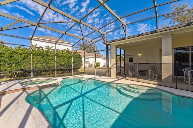 view of swimming pool featuring glass enclosure, a pool with connected hot tub, and a patio