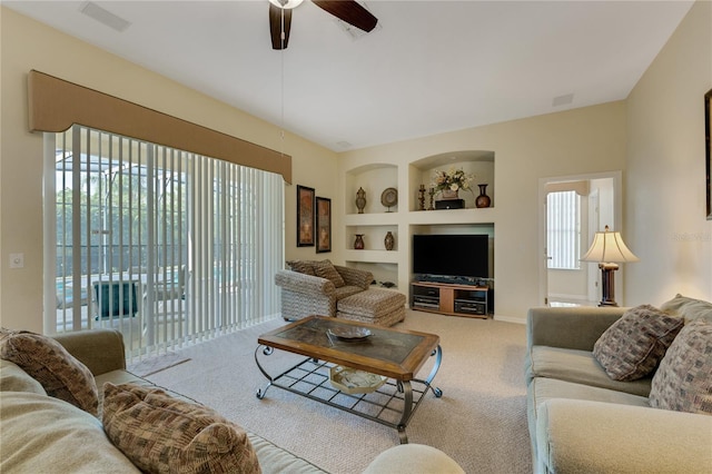 carpeted living room featuring ceiling fan, a healthy amount of sunlight, and built in features