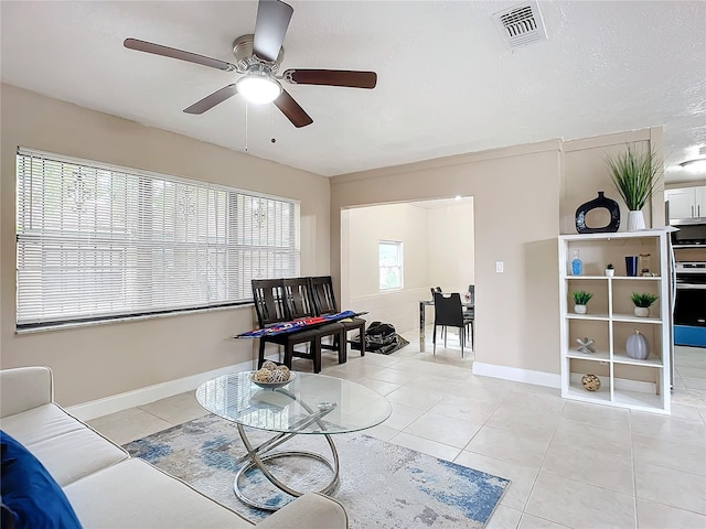 tiled living room with ceiling fan