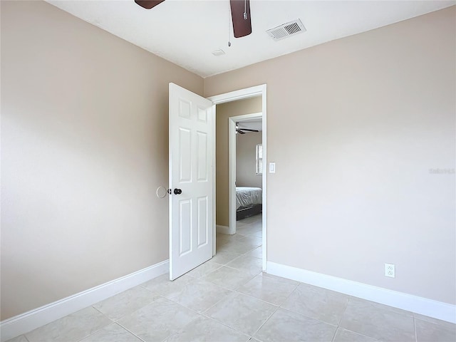 tiled empty room with ceiling fan