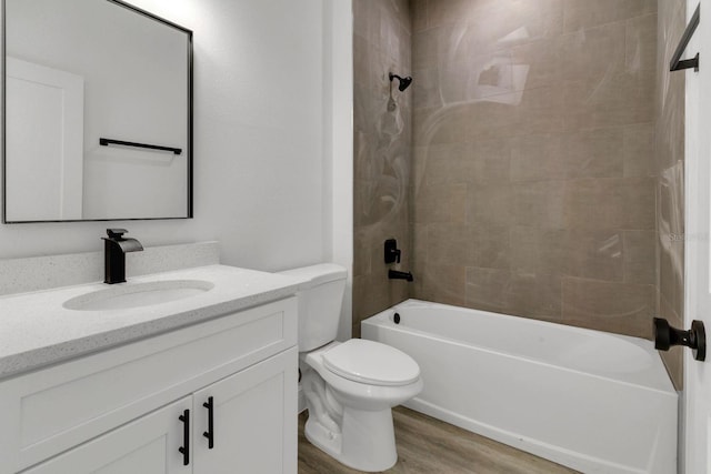 full bathroom featuring vanity, tiled shower / bath combo, wood-type flooring, and toilet