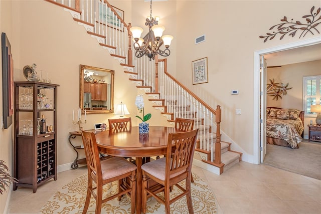 dining room with a towering ceiling, a chandelier, and light tile patterned flooring