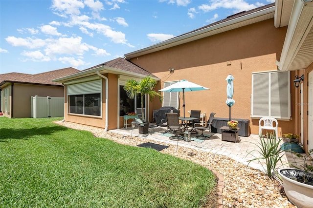 back of house featuring a patio area and a lawn