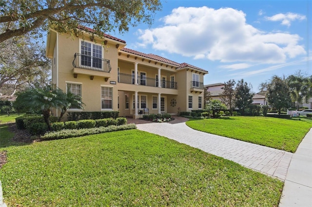 view of front of home with a front lawn and a balcony