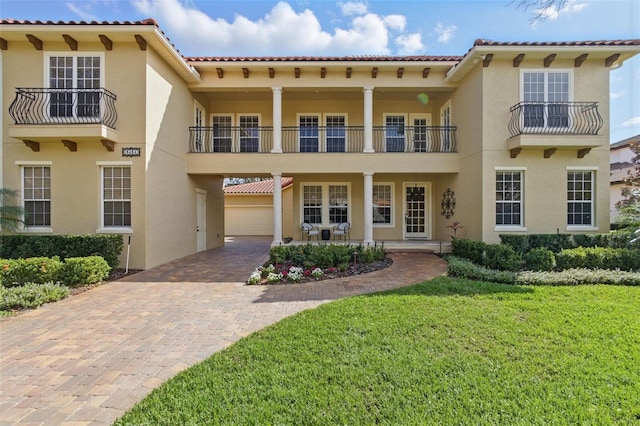 mediterranean / spanish-style house featuring a garage and a front lawn