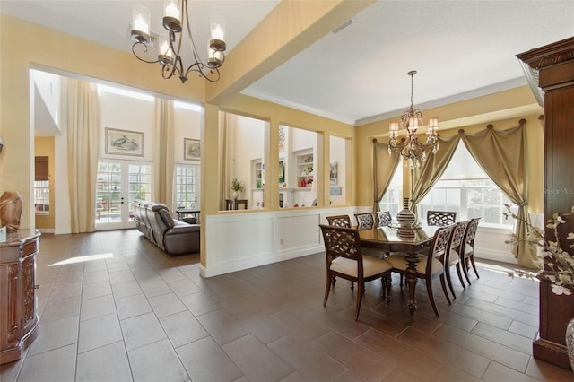 dining space with crown molding and a notable chandelier