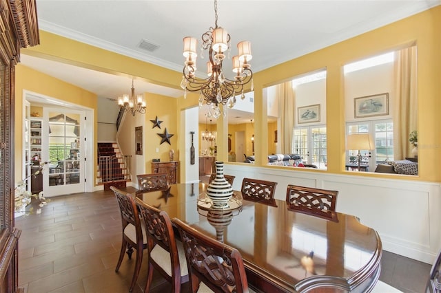 dining space with ornamental molding and a notable chandelier