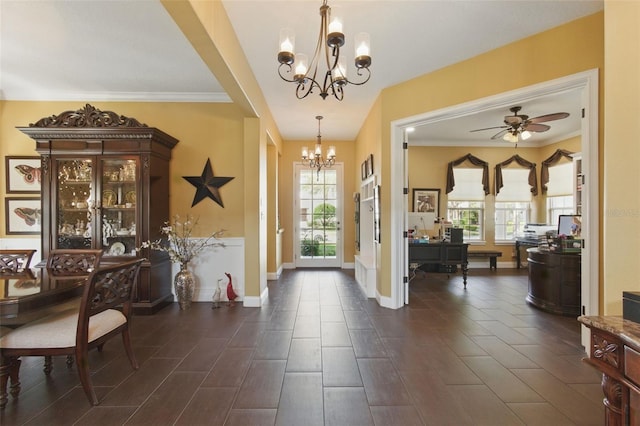 foyer with ornamental molding, a healthy amount of sunlight, and ceiling fan with notable chandelier