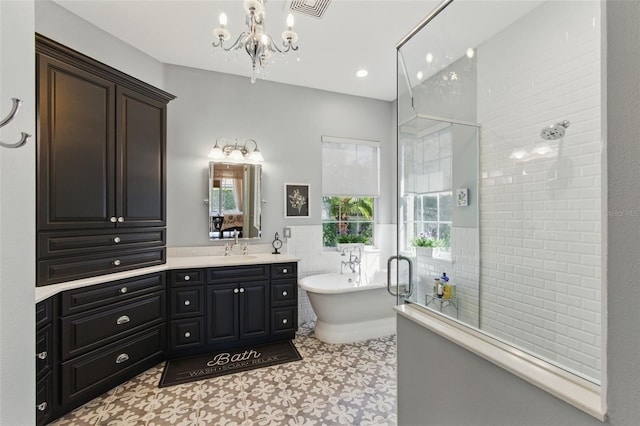 bathroom with independent shower and bath, vanity, tile walls, and a chandelier