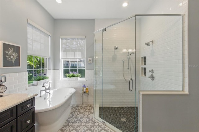 bathroom with vanity, tile walls, and plus walk in shower