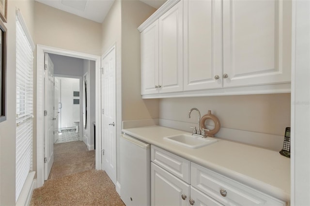 interior space featuring white cabinetry, sink, light colored carpet, and white dishwasher