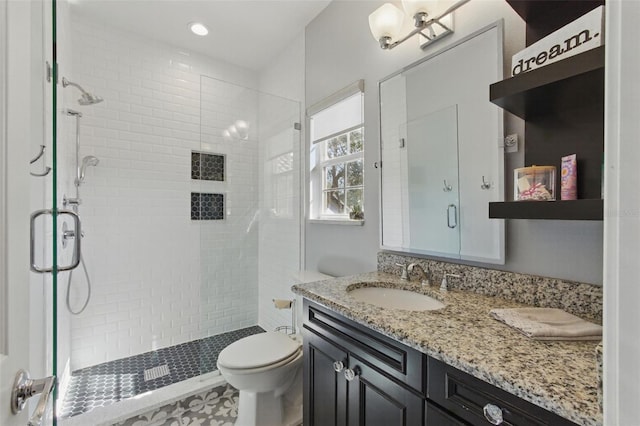 bathroom with vanity, toilet, and a shower with door